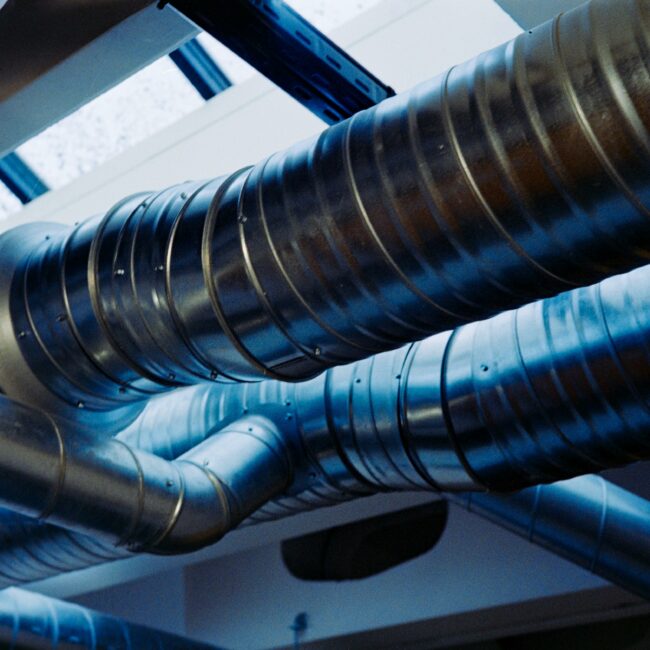 Close-up of a modern metallic ventilation system in an industrial setting.